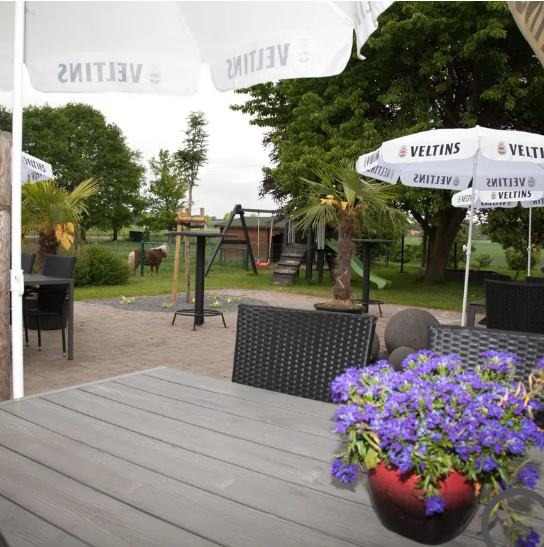 Biergarten mit Blick auf Spielbereich und Außenanlage